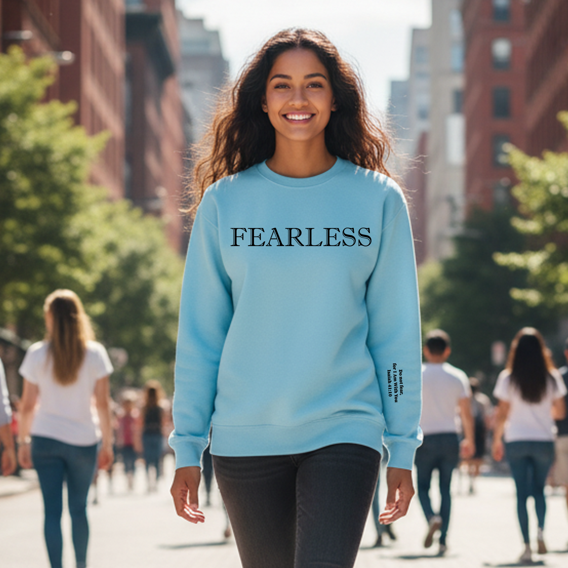 Woman wearing a light blue sweatshirt with 'FEARLESS' text on a city street.
