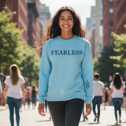 Woman wearing a light blue sweatshirt with 'FEARLESS' text on a city street.
