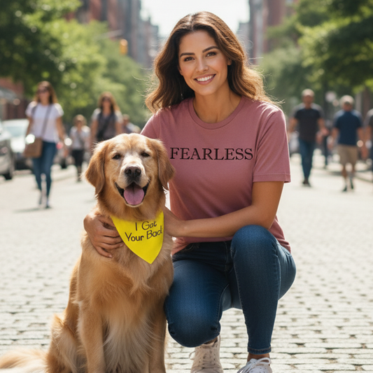 Woman in a 'FEARLESS' shirt with a golden retriever on a city street.