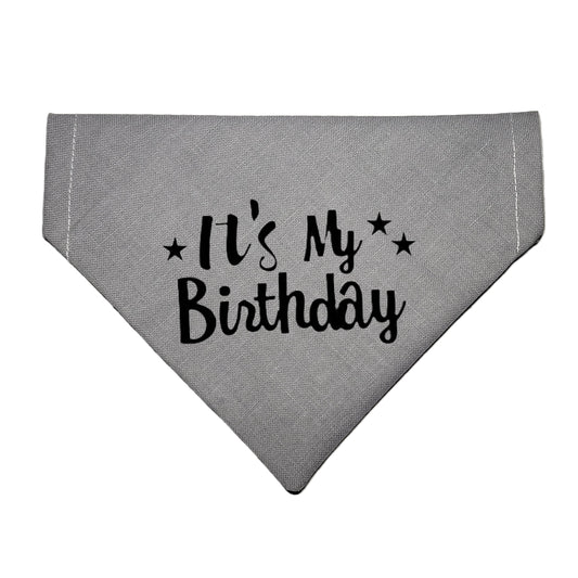  a gray dog bandana with black stars and lettering that reads It's My Birthday 